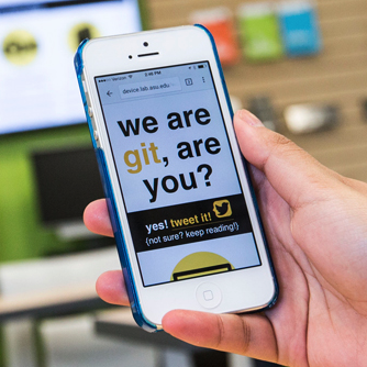 a hand holding an older iPhone with a web page displaying on it that says we are g.i.t., are you?